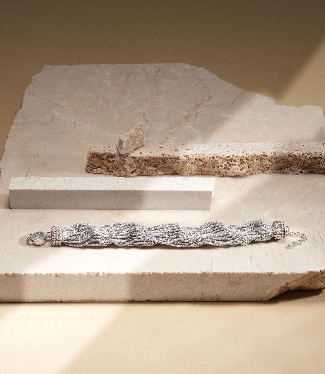 <p>Bracciale in oro bianco e seta grigia</p>