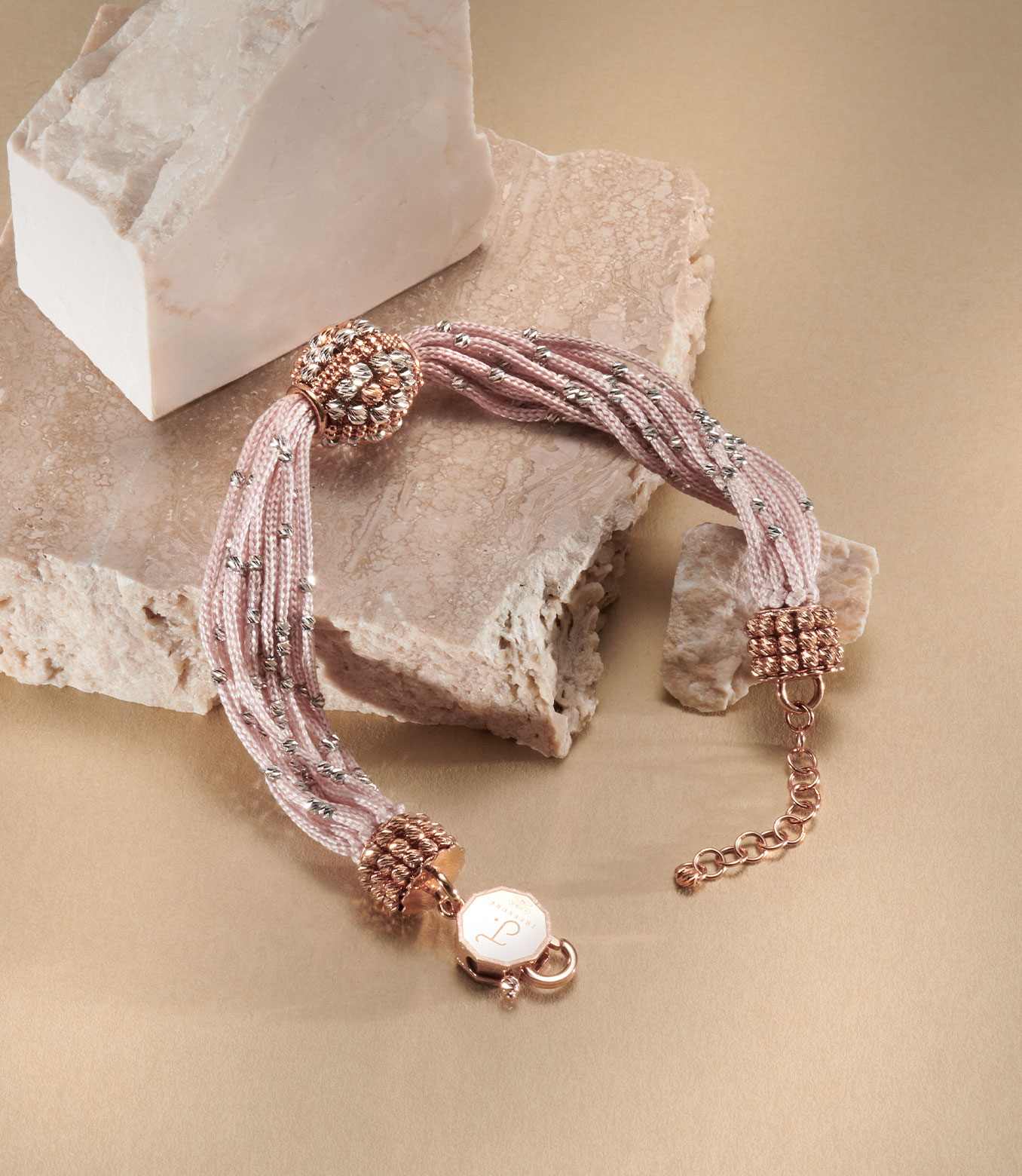 <p>Bracciale in oro rosa e bianco e seta rosa</p>