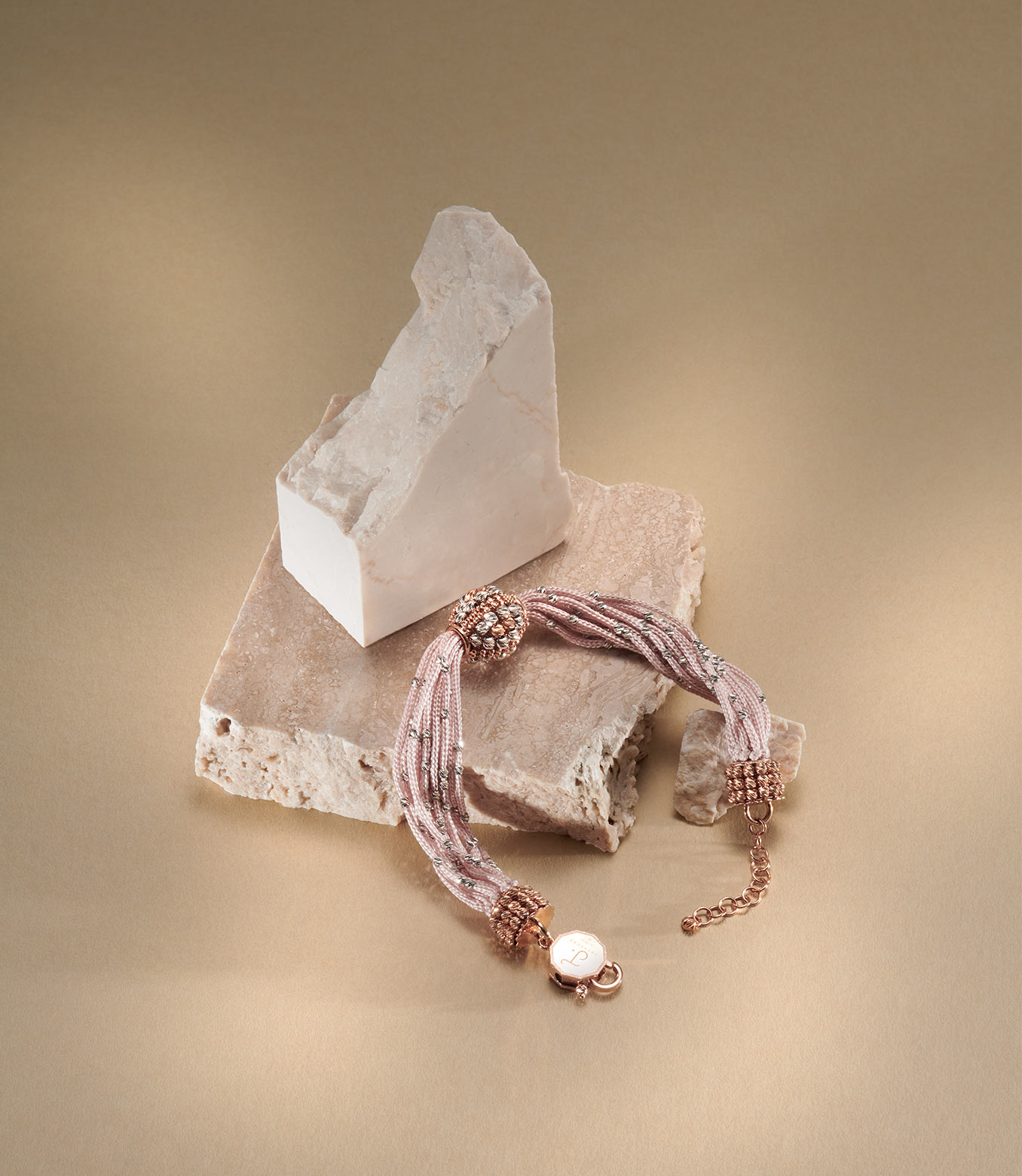 <p>Bracciale in oro rosa e bianco e seta rosa</p>