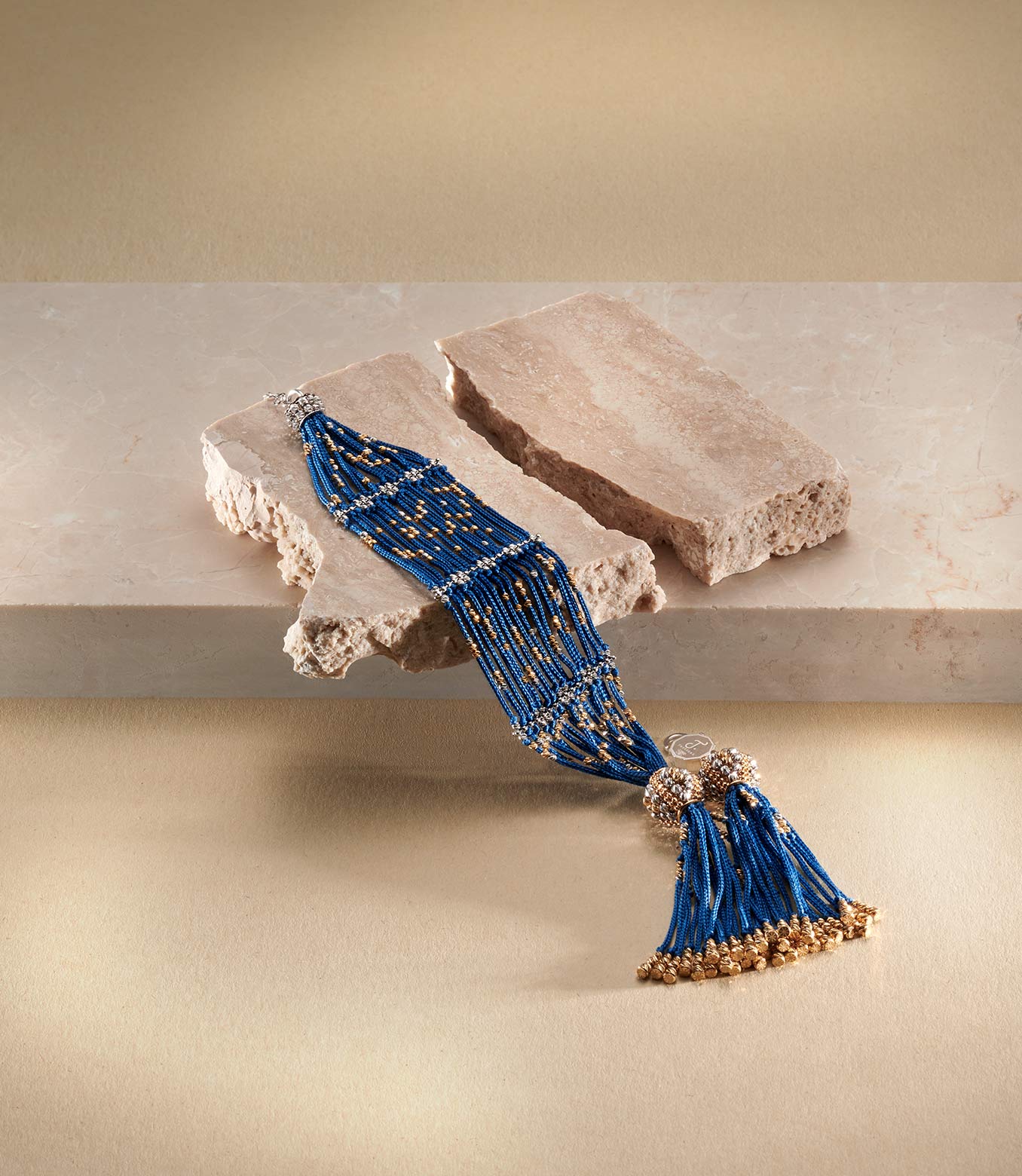 <p>Bracciale in oro giallo e bianco e seta blu</p>