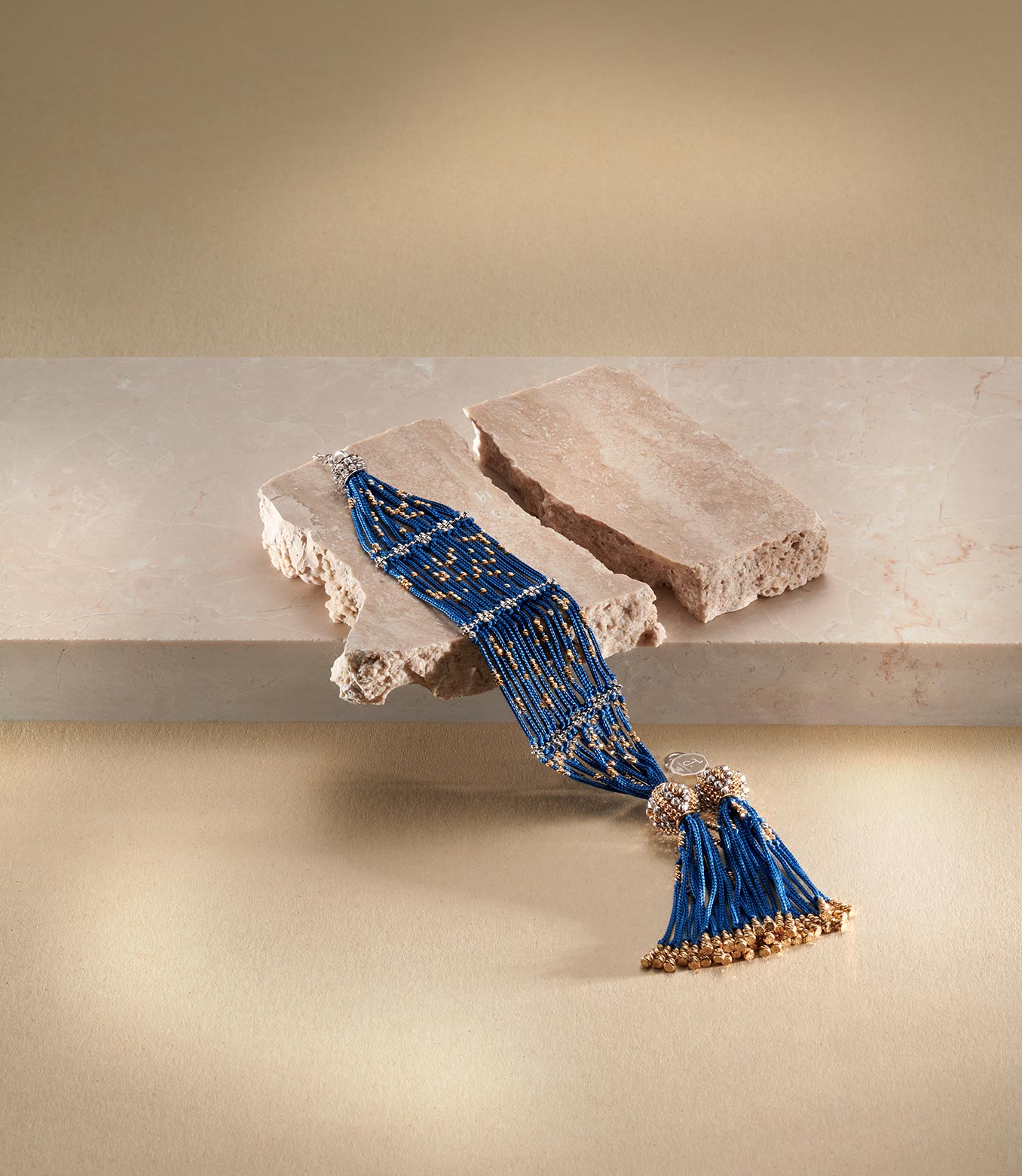 <p>Bracciale in oro giallo e bianco e seta blu</p>