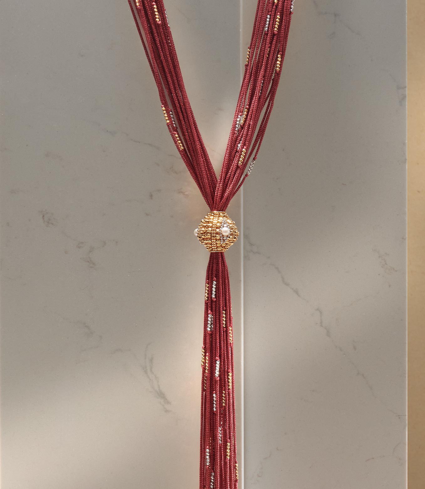 <p>Collana in oro giallo e bianco e seta rossa con perle</p>