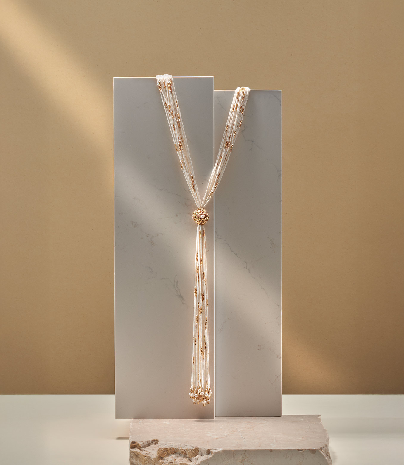 <p>Collana in oro giallo e seta bianca con perle</p>