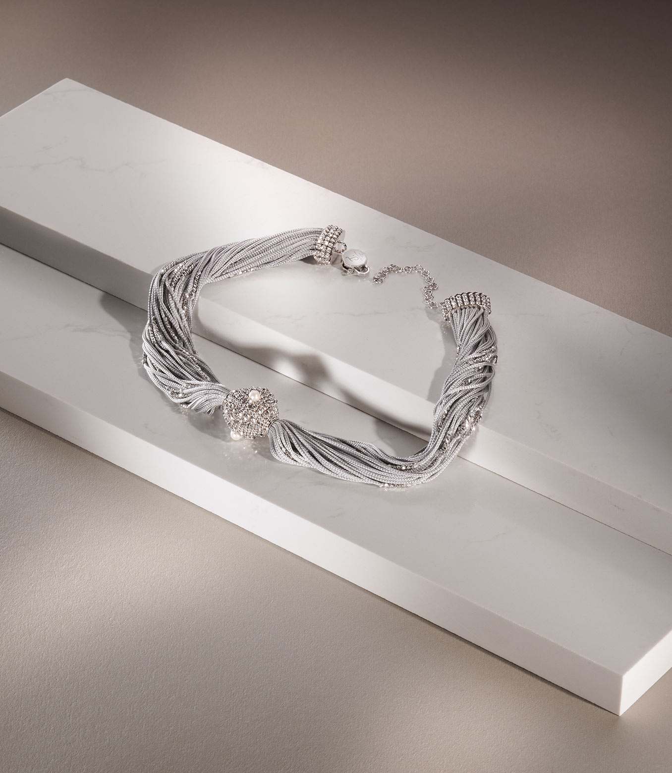 <p>Collana in oro bianco e seta grigia con perle</p>