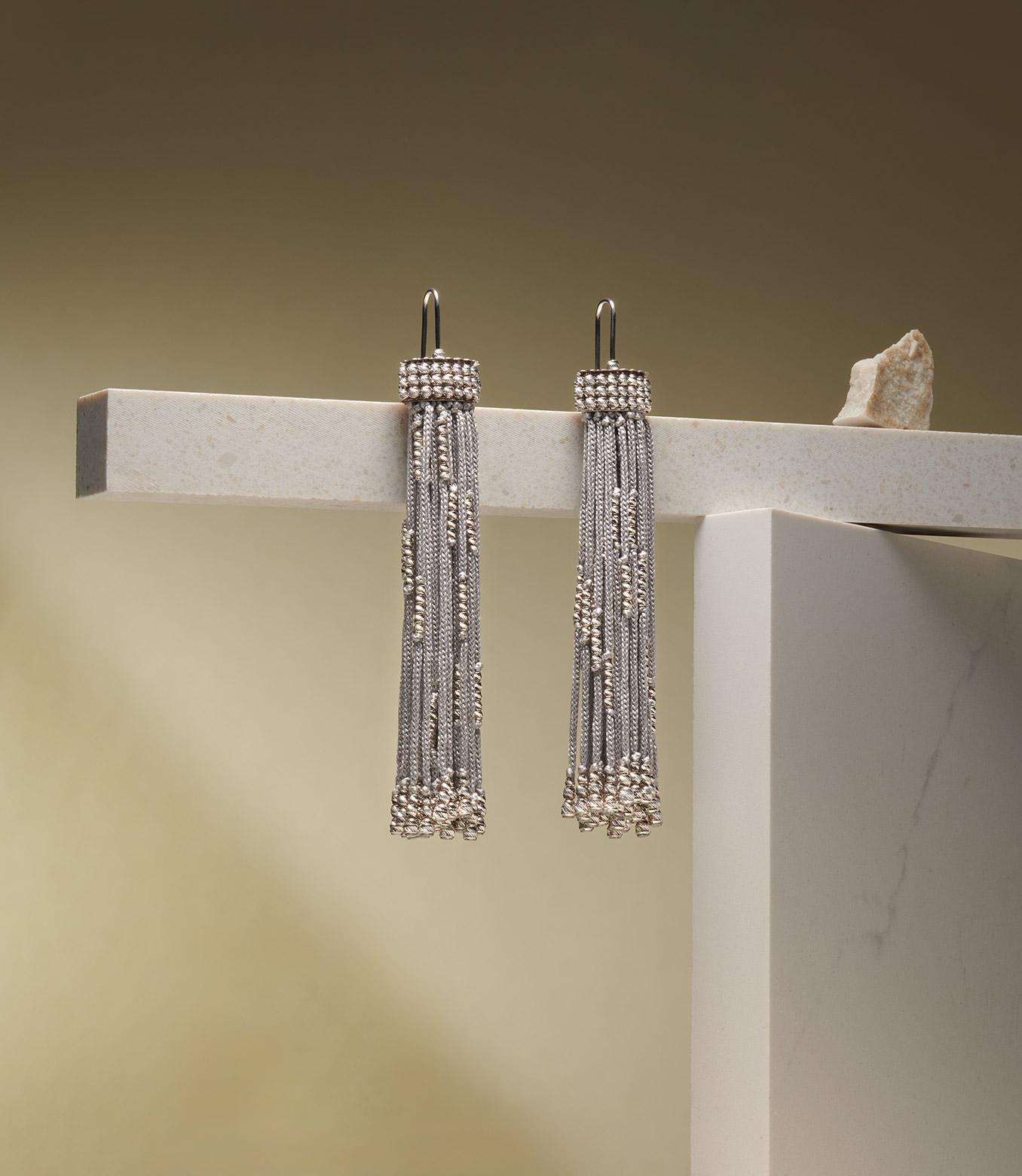 <p>Earrings in white gold and grey silk</p>